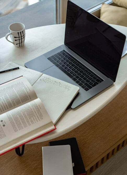 Un tavolo con computer e libri per un apprendimento continuo